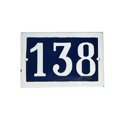 Navy blue rectangular plate with white numbers '138' on a white background