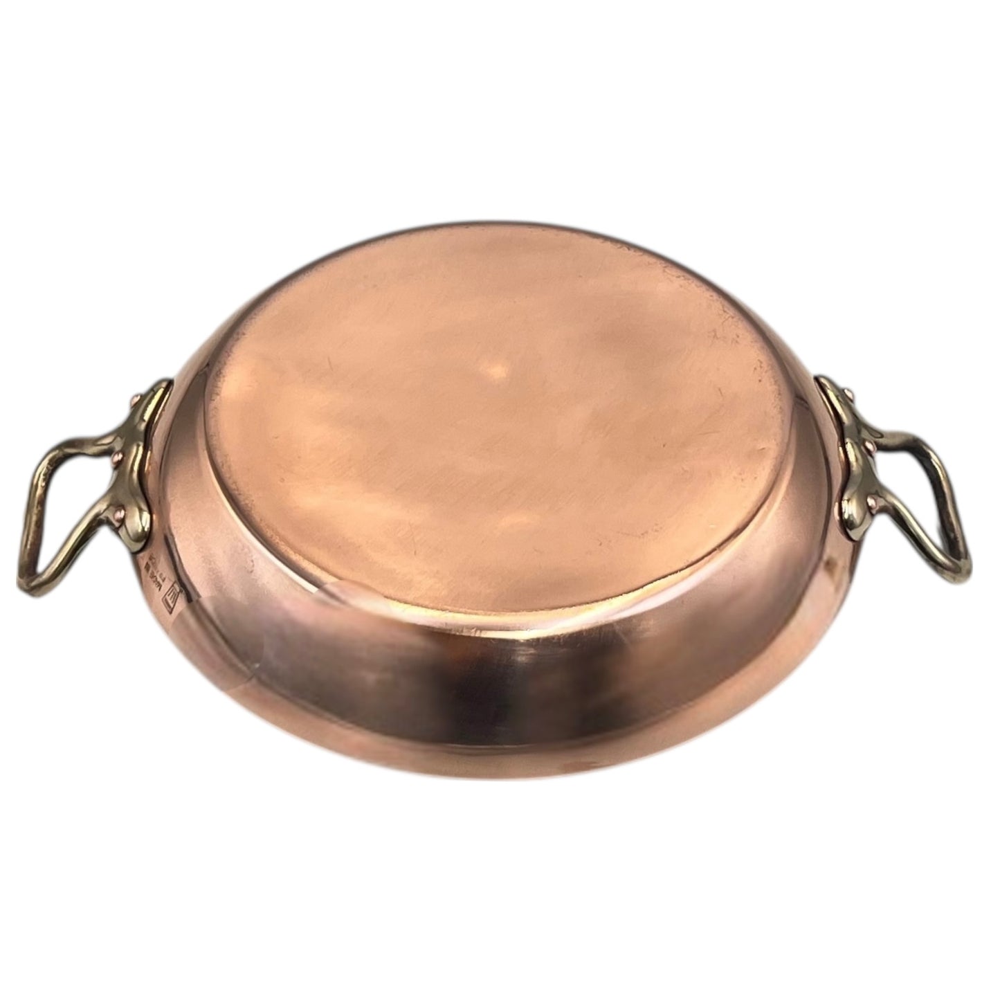 French copper round gratin pan with brass handles on a white background