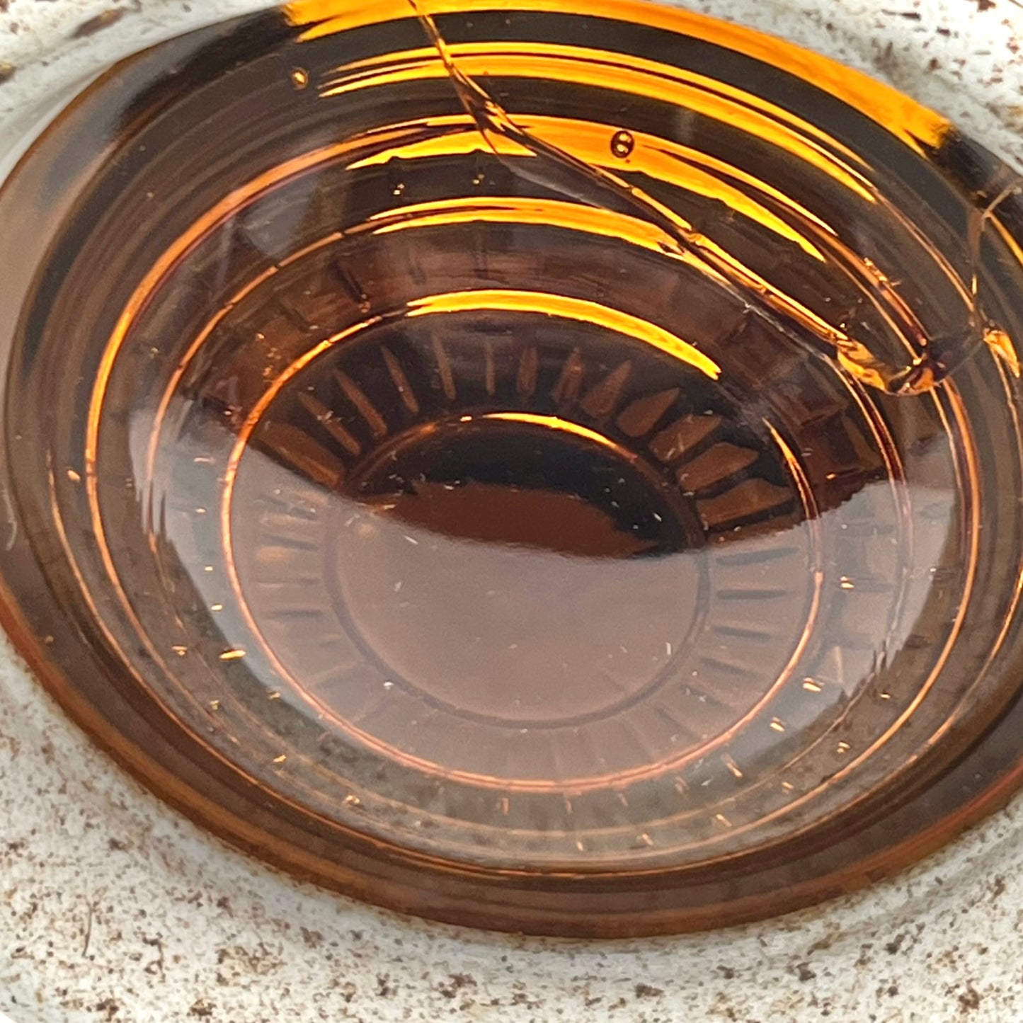Close up of yellow vintage railway or railroad lamp with orange glass panels and a hook on a white background