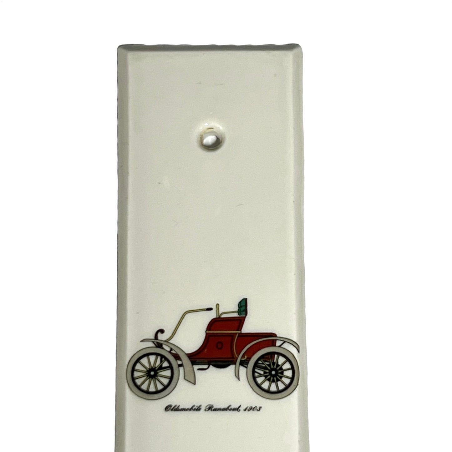 Close up of fingerplate with vintage car illustrations on a white background