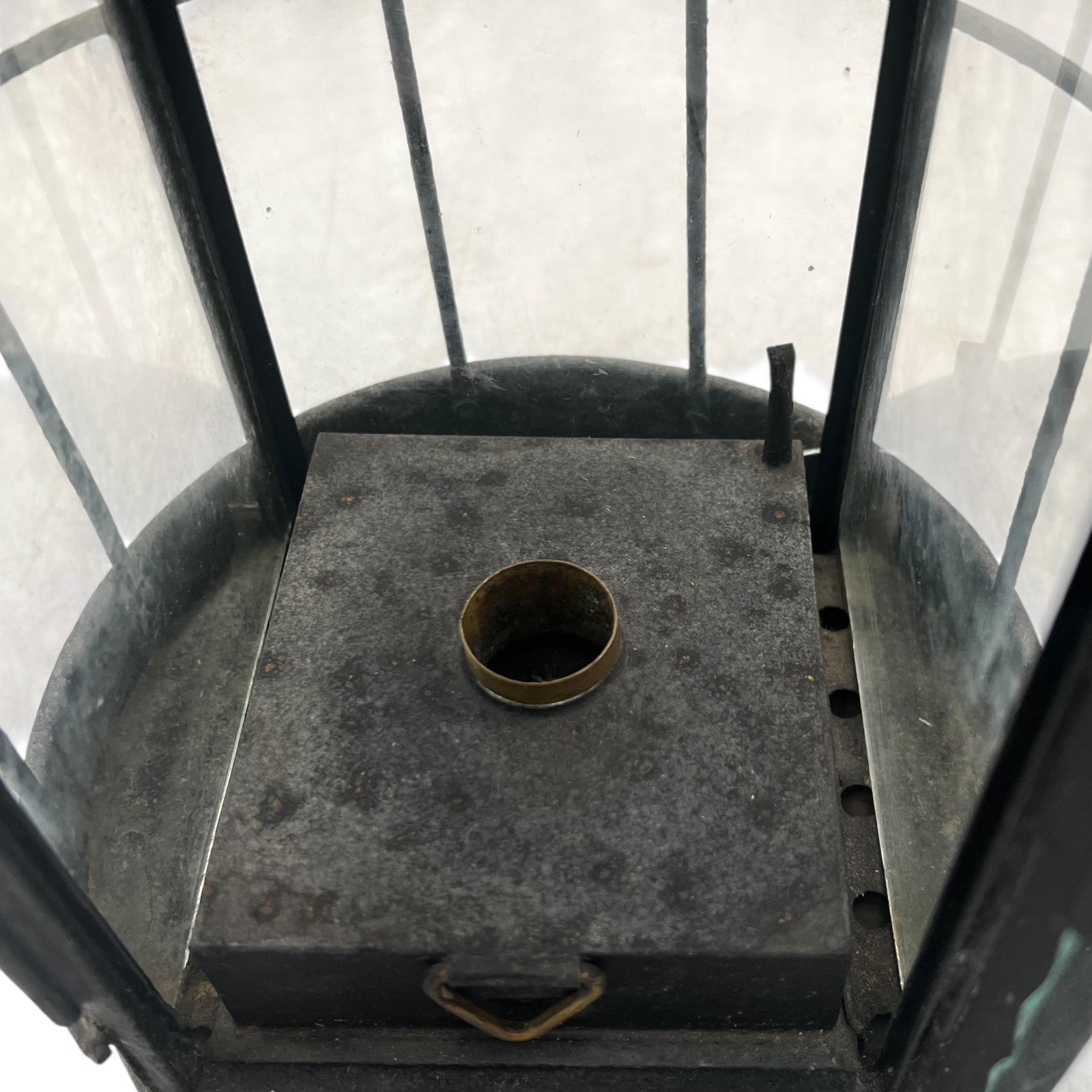 Metallic surface inside a glass-enclosed structure with a circular metal component.