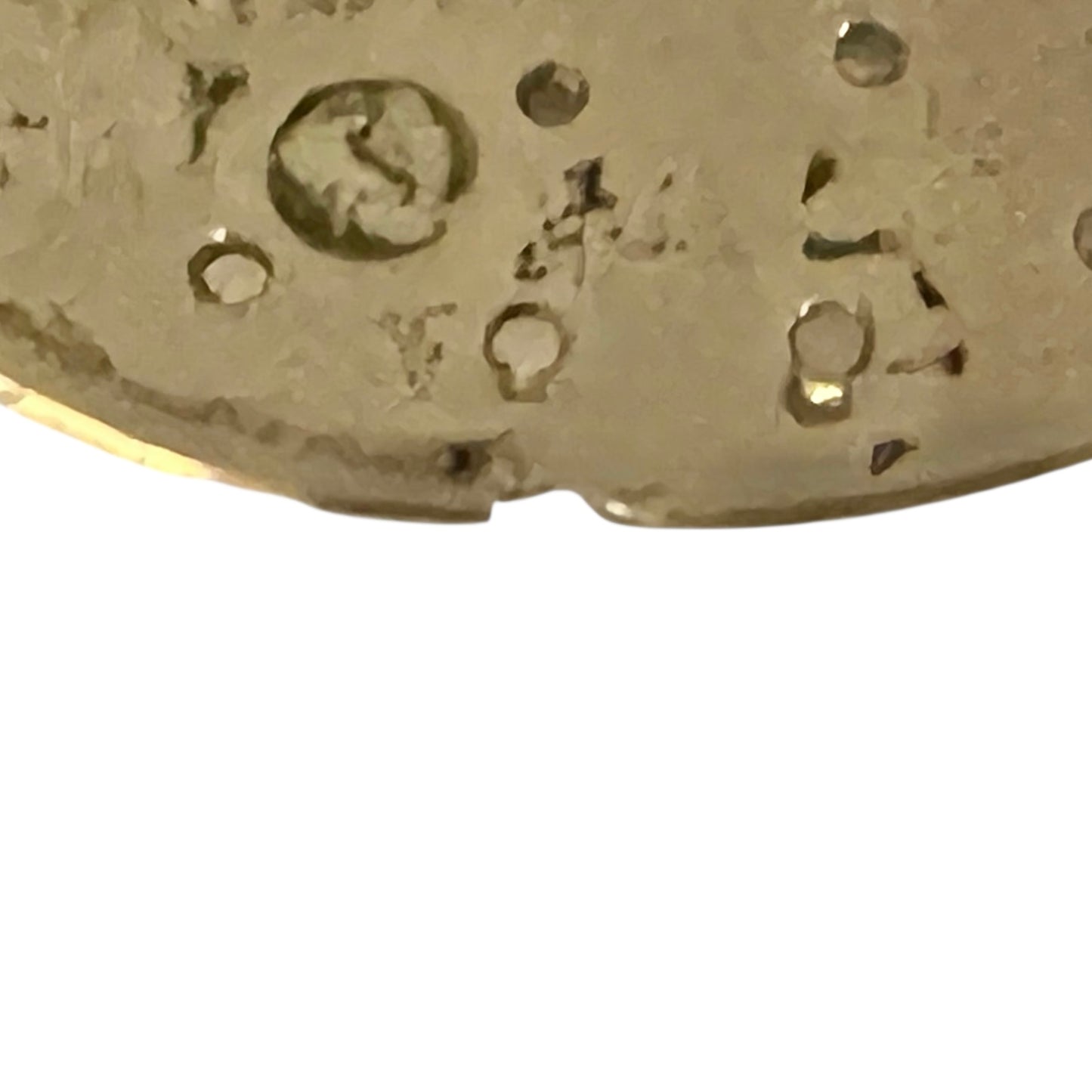 Close-up of a gold object with engraved text on a white background