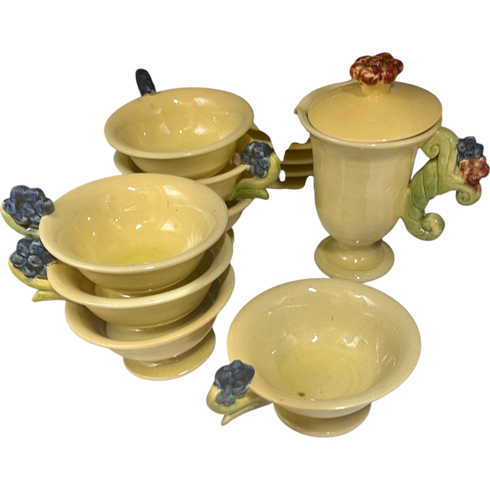 Set of ceramic plates and cups with decorative handles on a white background