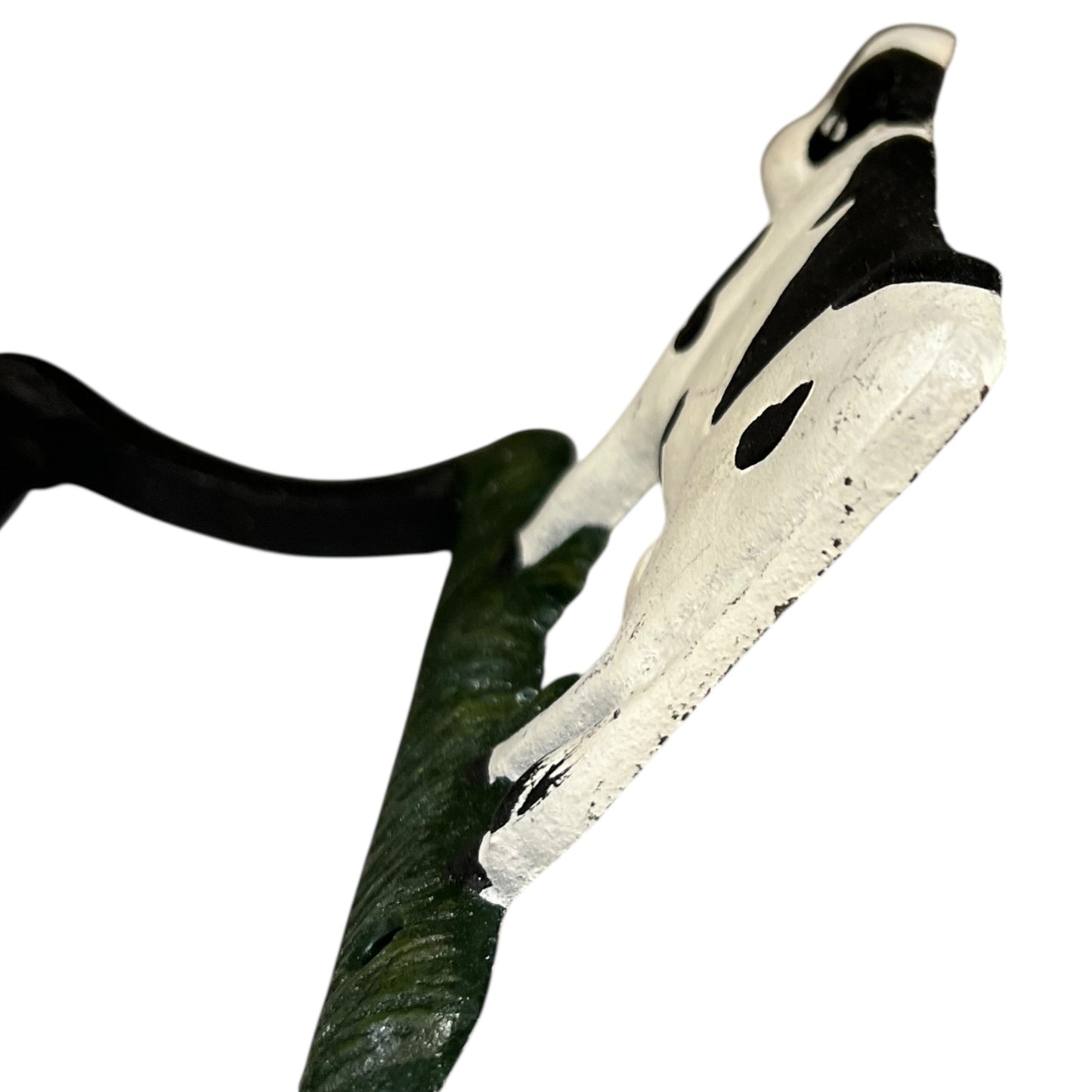 Close up of cow toilet paper holder with black and white pattern on a white background