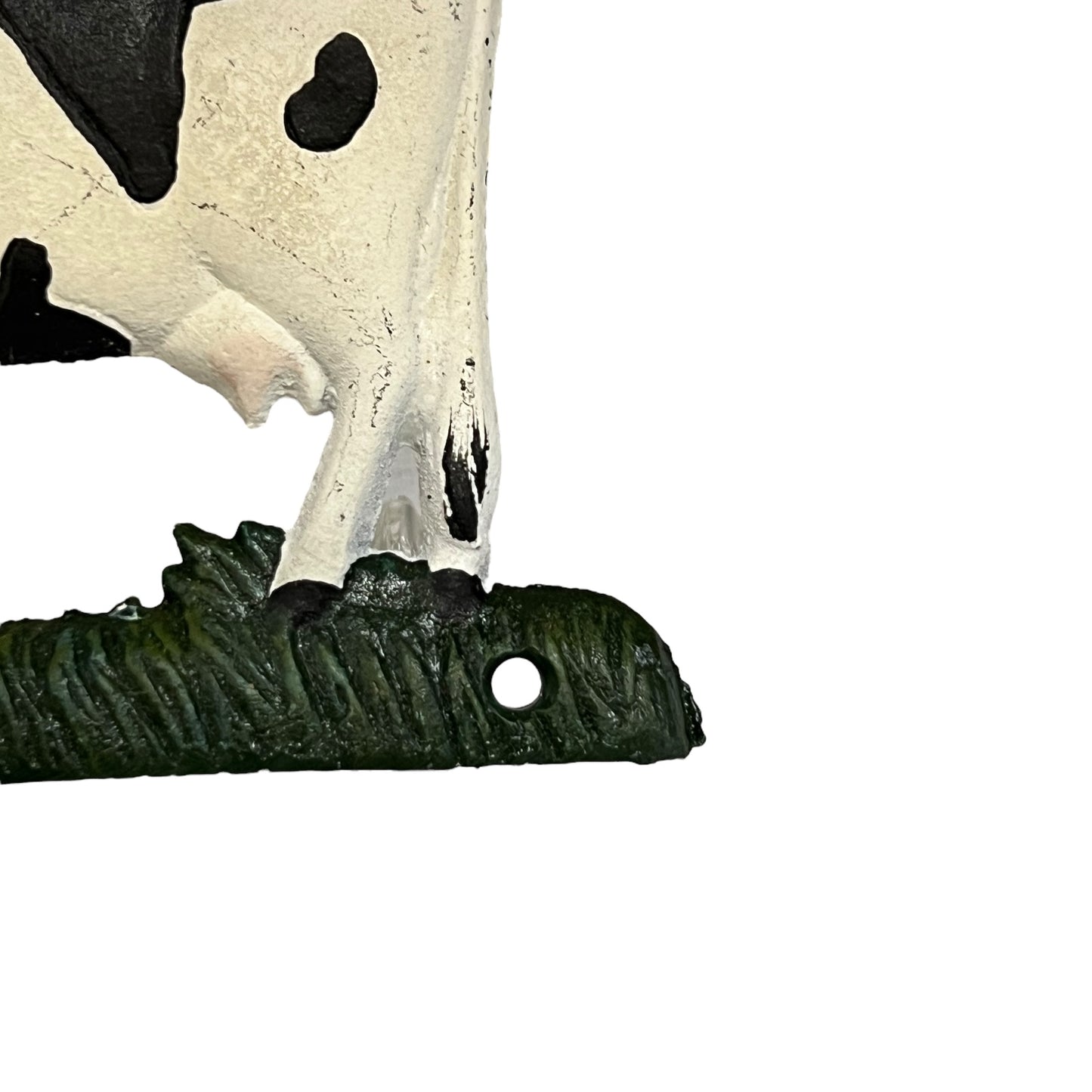 Close up of cow toilet paper holder with black and white pattern on a white background