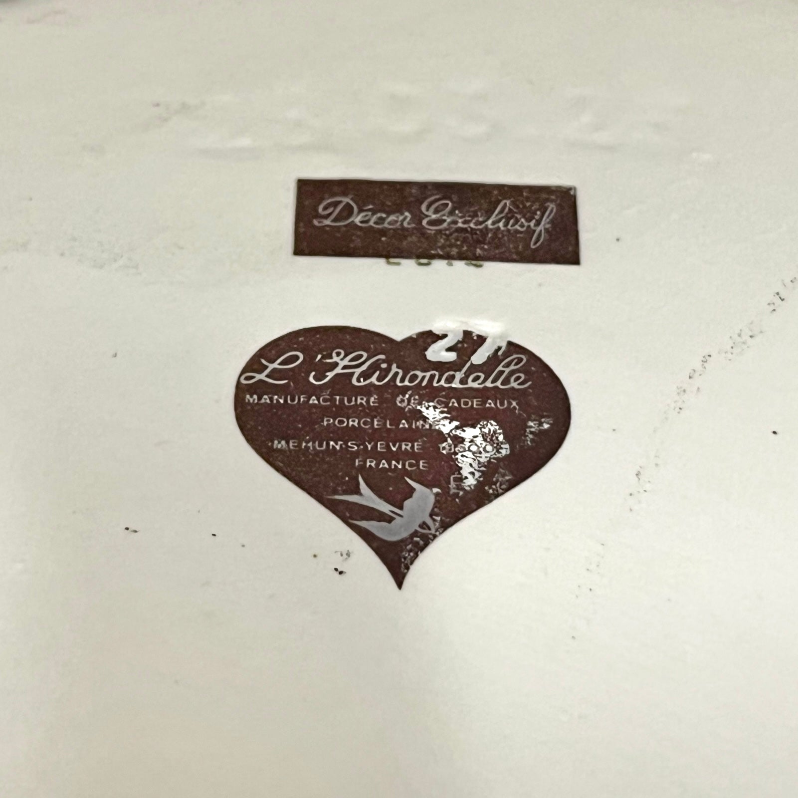 Decorative label on a ceramic item with 'L'Hirondelle' branding.