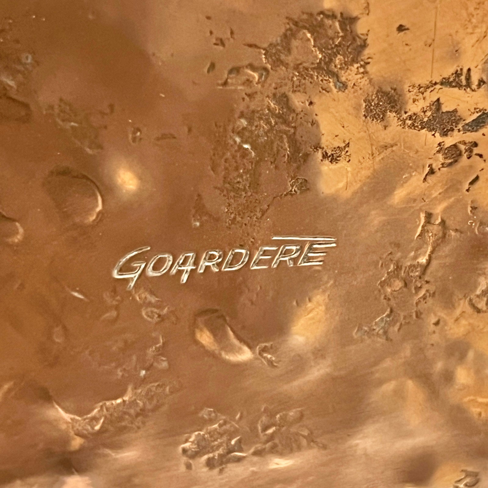 Close-up of a copper milk churn with a chain handle on a white background