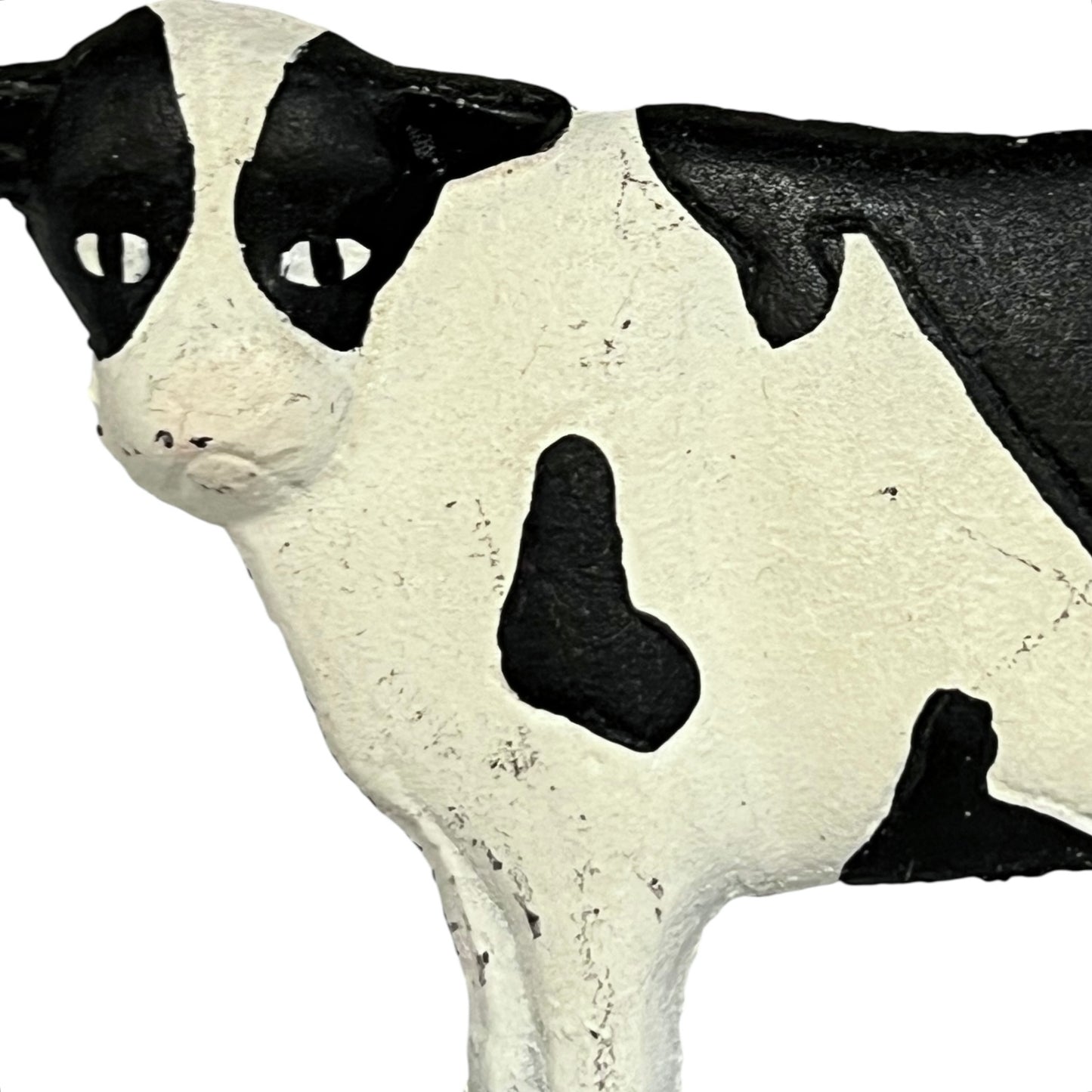Close up of cow toilet paper holder with black and white pattern on a white background