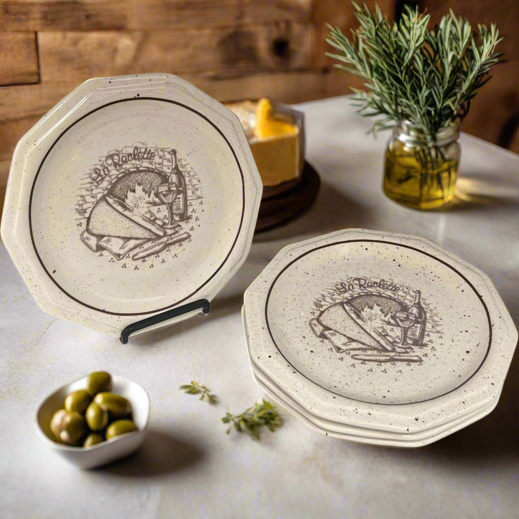 Set of 4 La Raclette plates with a decorative design on a white background