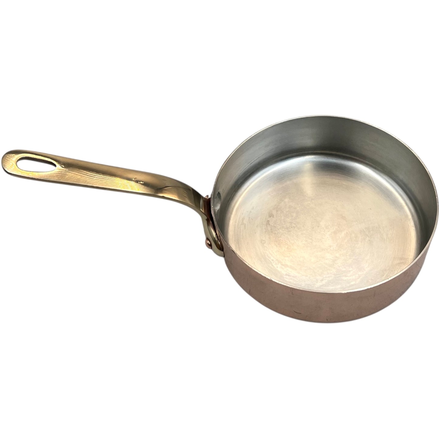 Small copper frying pan with a brass handle and tin lining on a white background