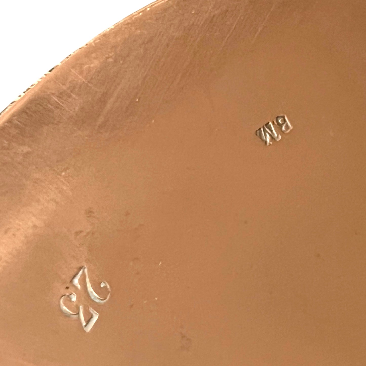Close up of authentic vintage French copper pan lid showing the number 23 and a pair of initials on a white background