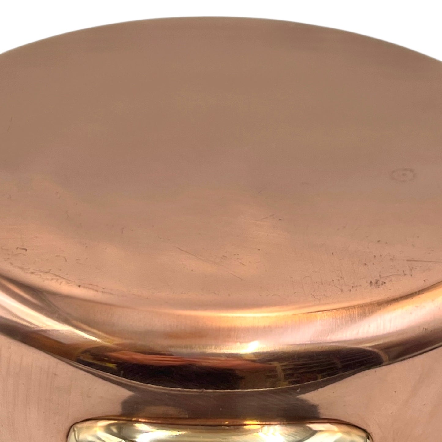 Small copper frying pan with a brass handle and tin lining on a white background