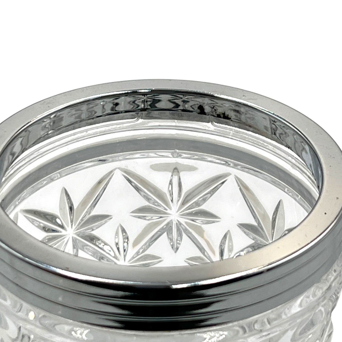 Clear French cut glass ice bucket with textured design and metal handle on a white background
