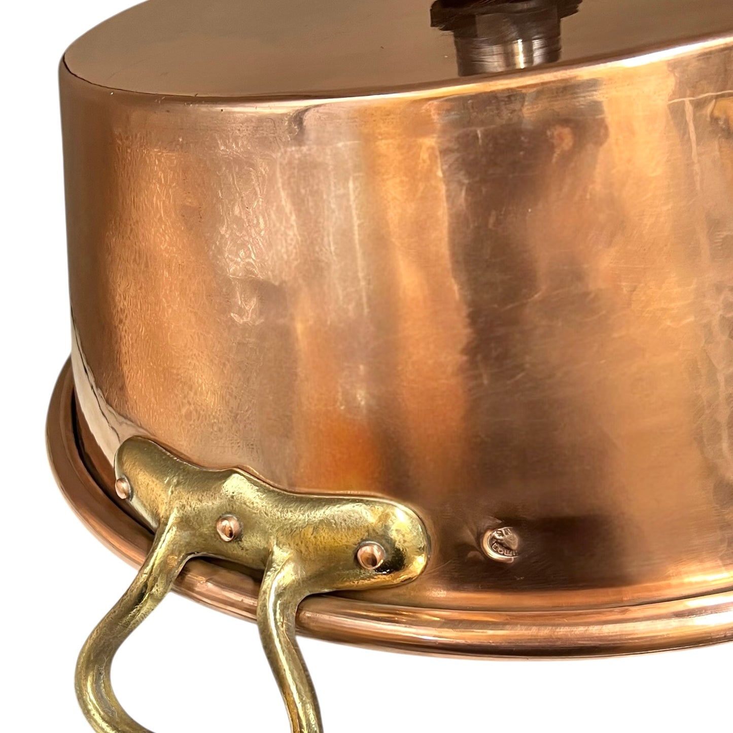 Close-up of copper sink with brass pop up waste on a white background