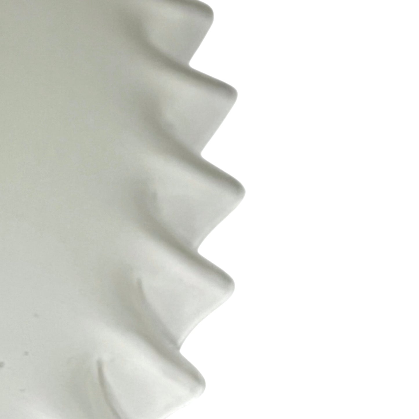 Close-up of a white lampshade with wavy design on a white background