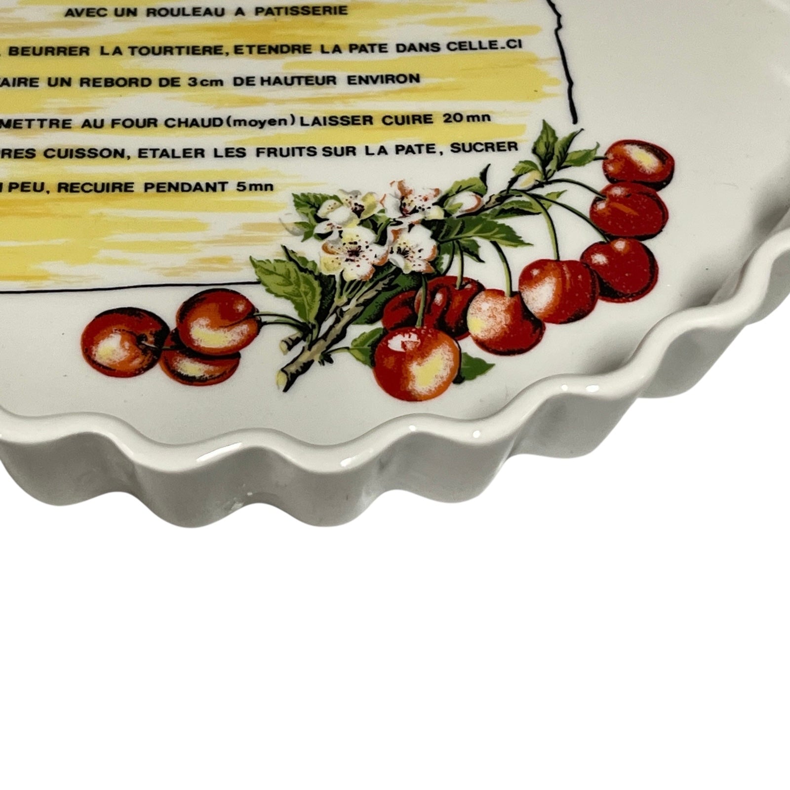 Decorative tart dish with cherry design and recipe text on a white background