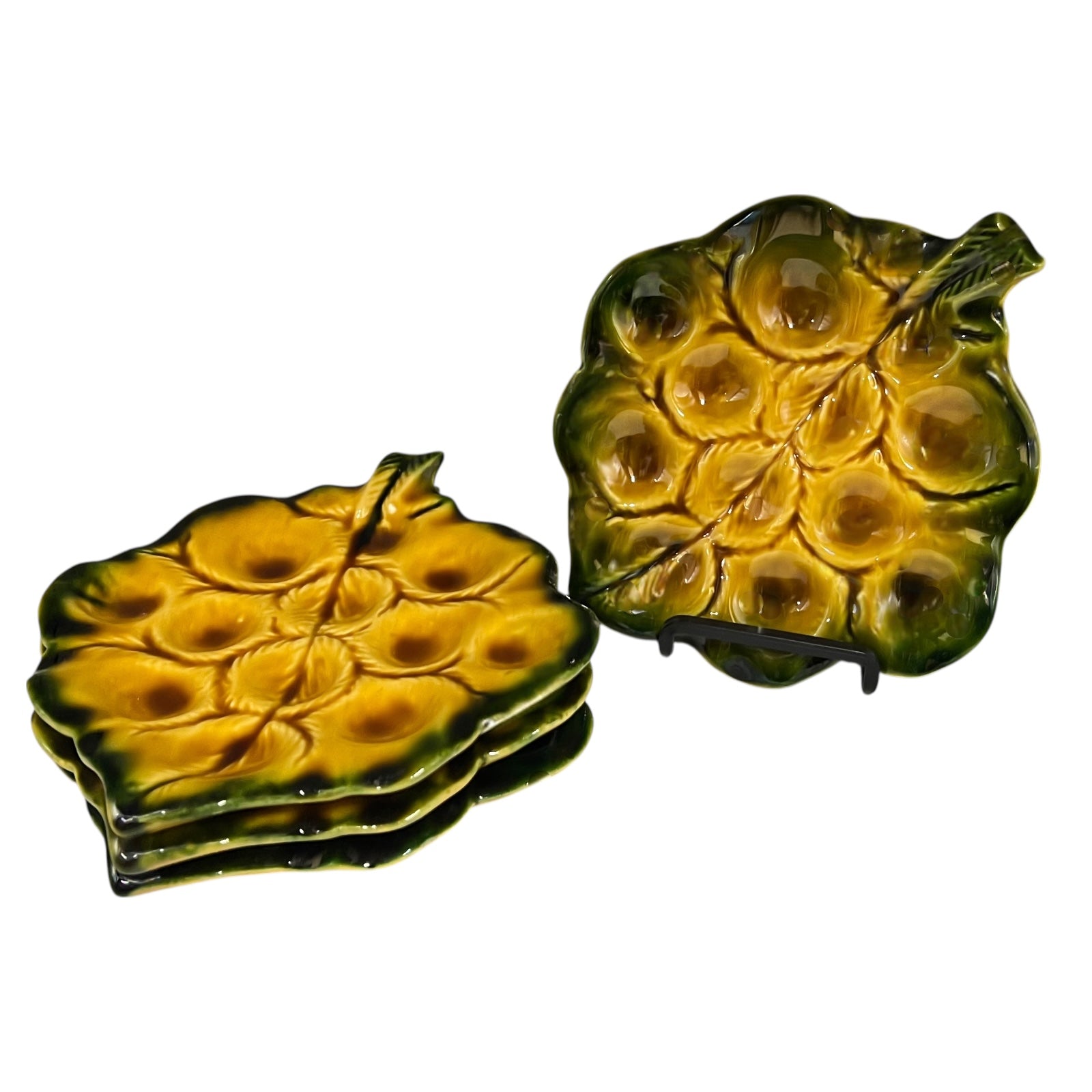 Set of green ceramic leaf-shaped snail escargots plates on a white background