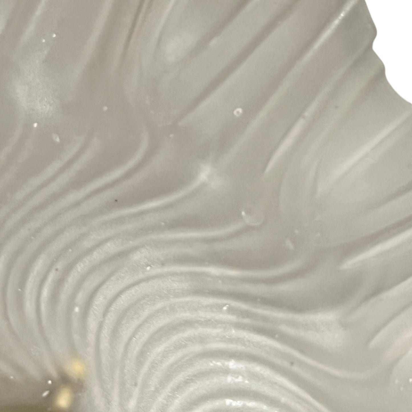 Close up of a glass lampshade and brass fittings on a white background