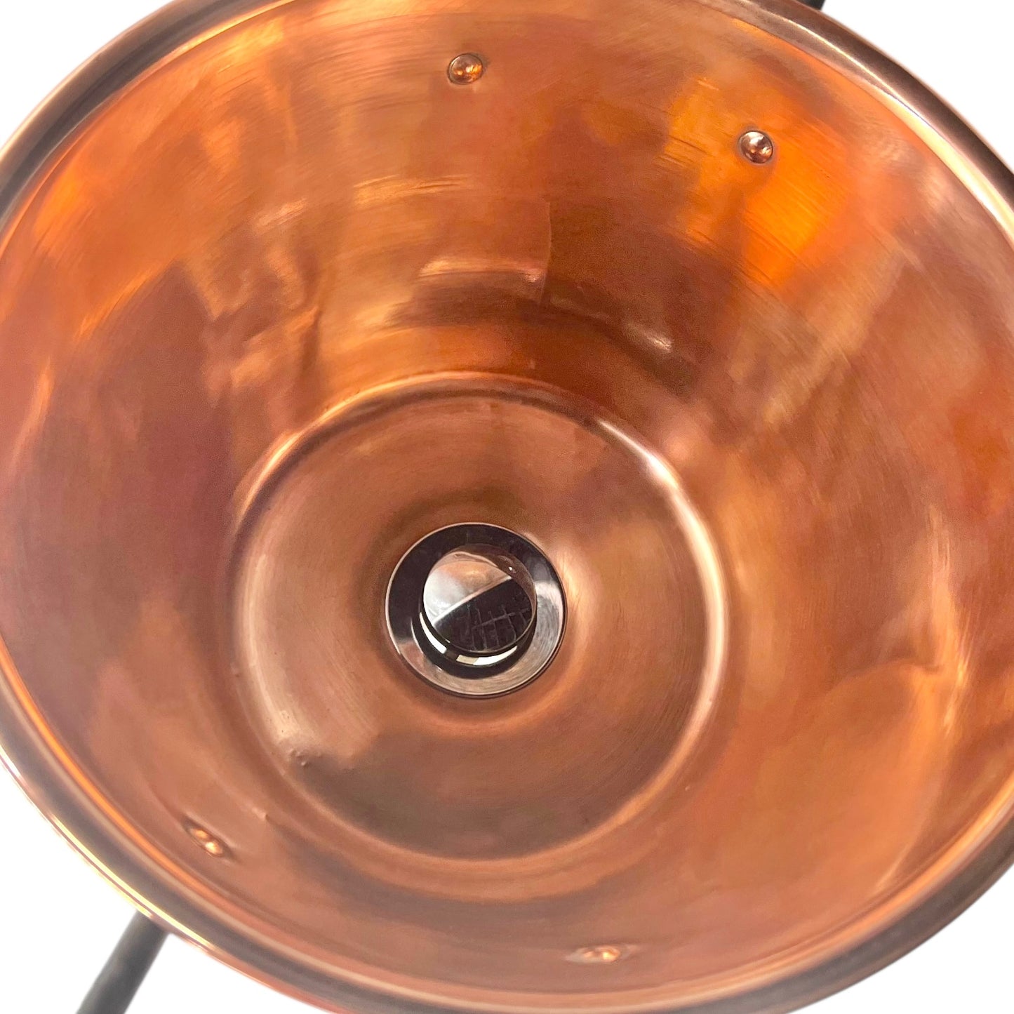 Close up of copper upcycled basin sink or washbowl with a chrome waste and black handles on a white background