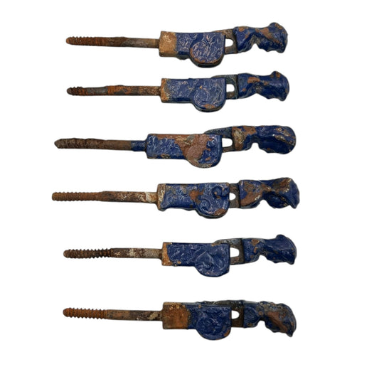 6 French cast iron shutter dogs painted blue with signs and age and wear on a white background