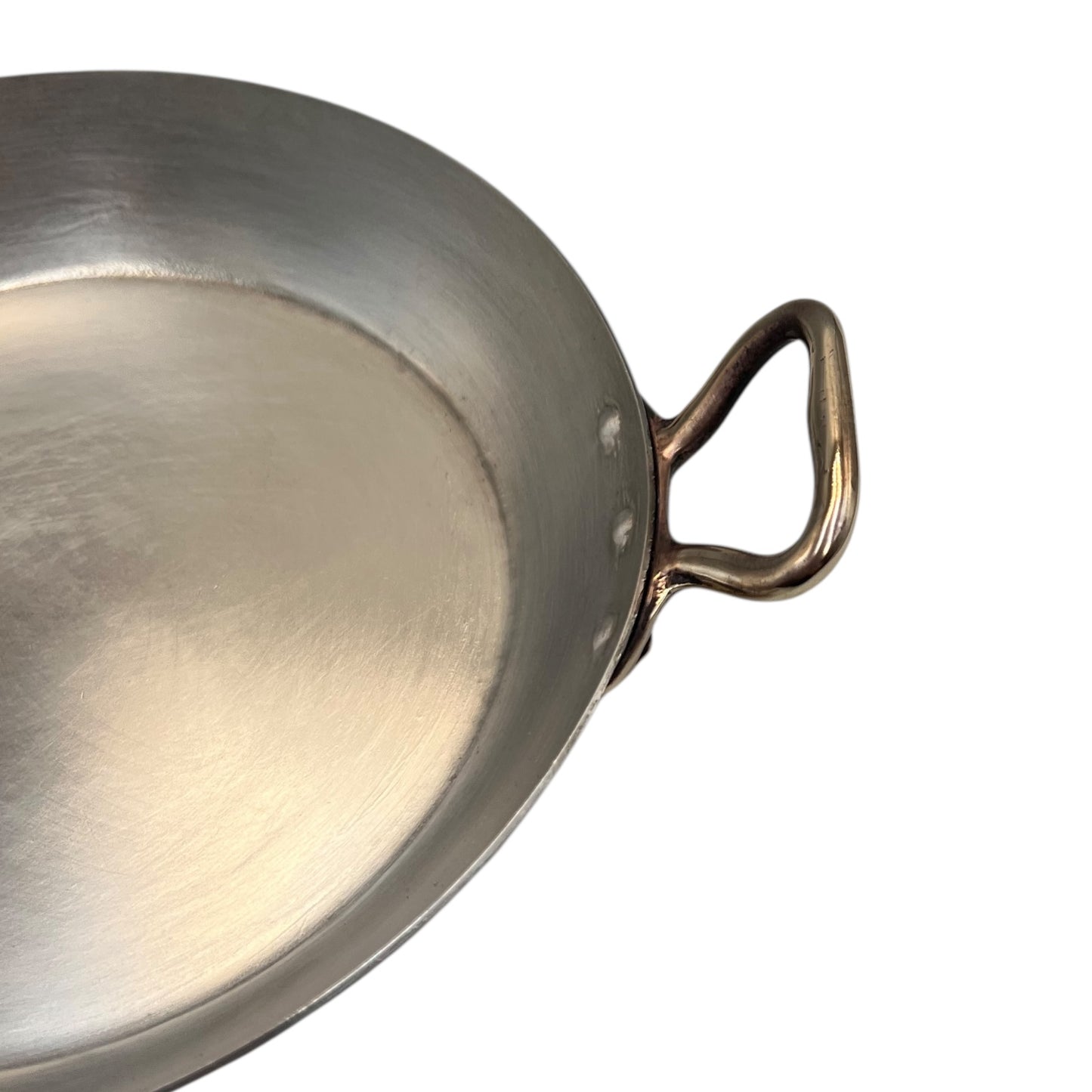 close up of French copper round gratin pan with brass handles and tin lining on a white background