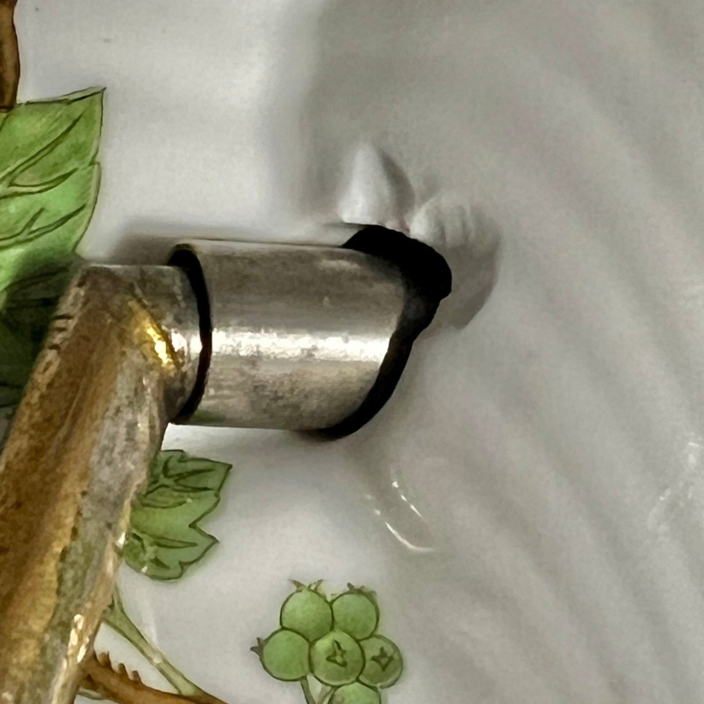 close up of towel hoop with leaf design on a white background