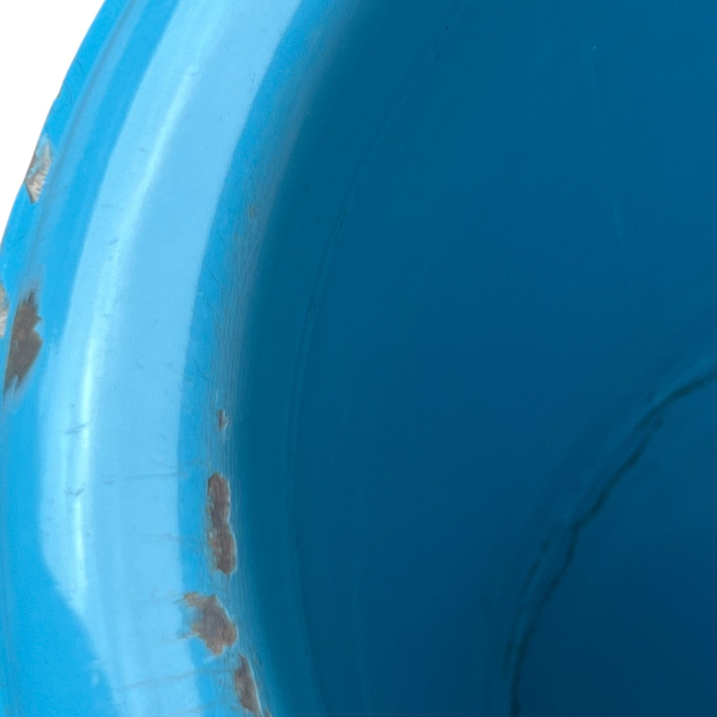 Close up of blue metal bucket with a wooden handle on a white background