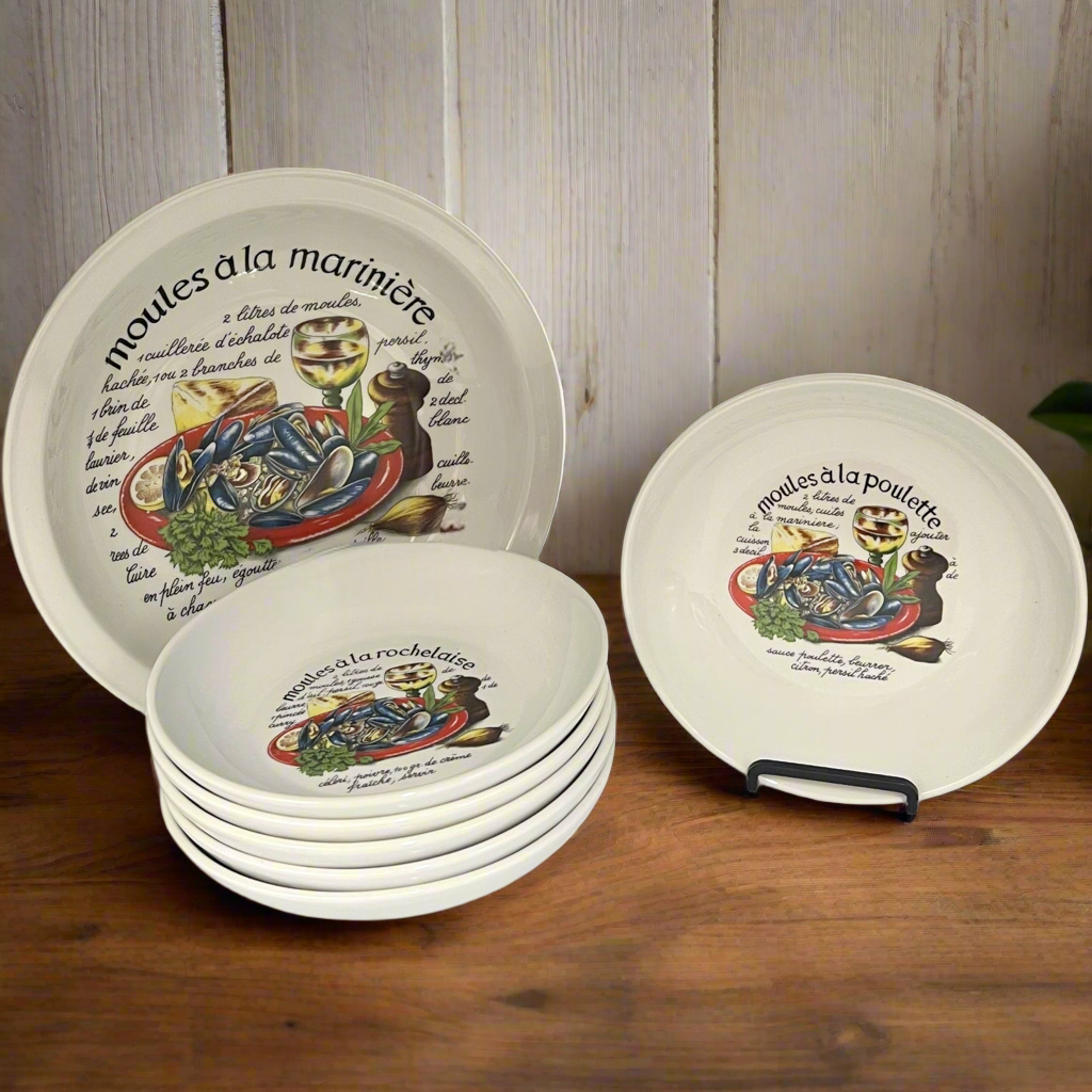 Set of decorative plates with French text and illustrations on a wooden surface.