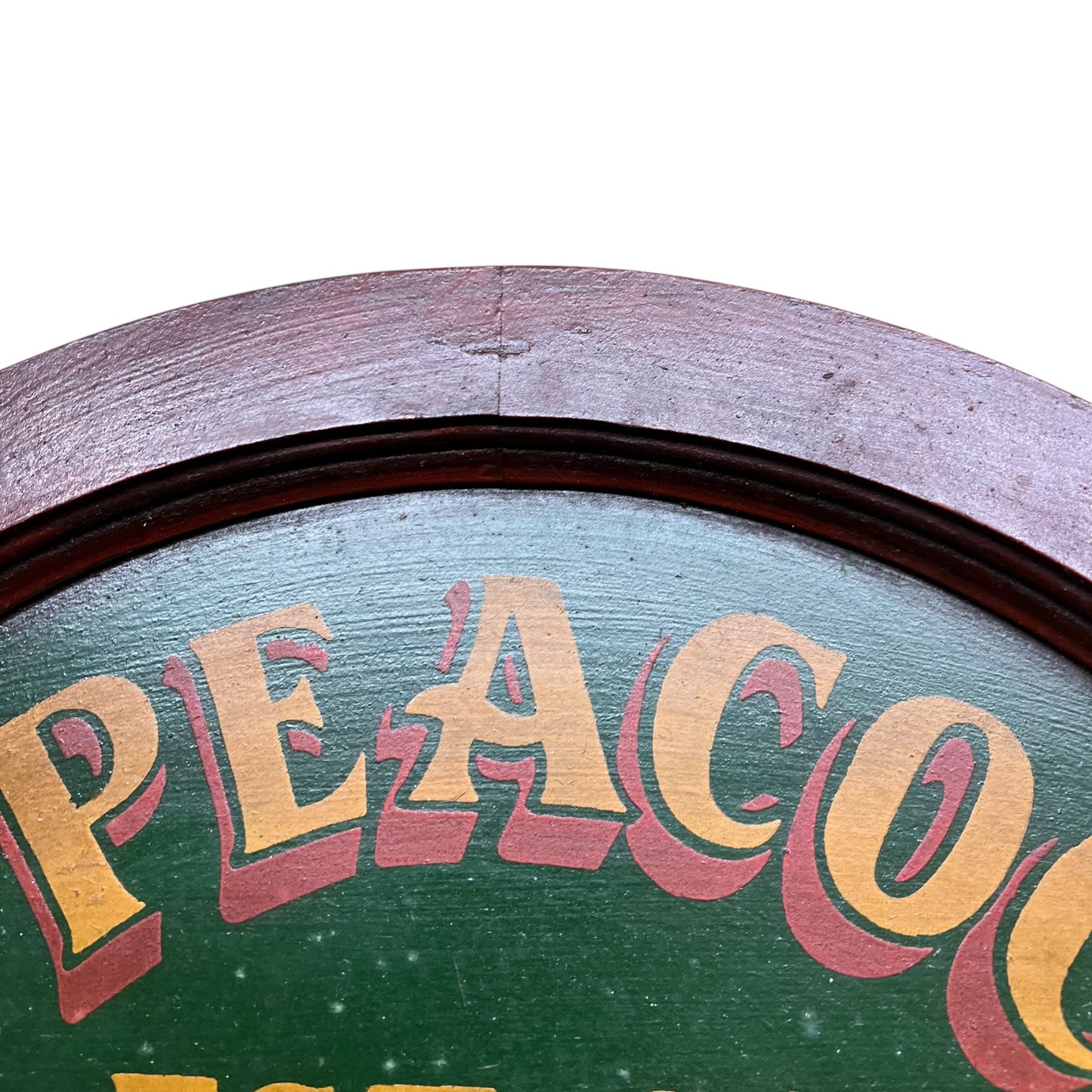 Vintage-style sign with 'PEACOCK' text on a green background