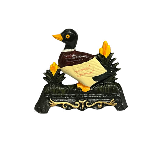 A decorative duck door stop on an ornate black base with gold scrollwork, set against a plain white background.
