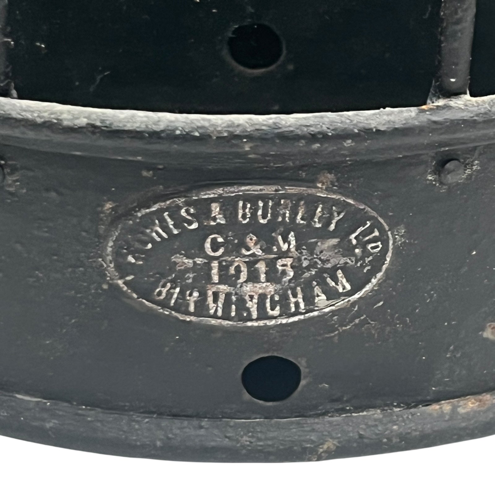 Close-up of a black metal object with engraved text on a white background