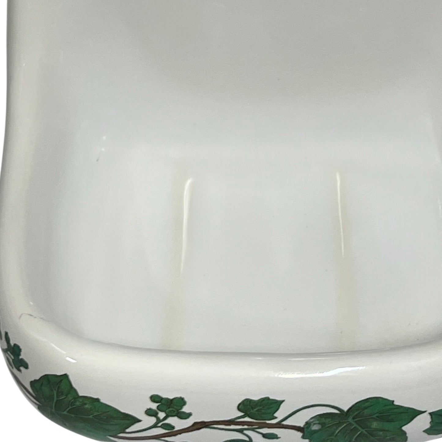 Porcelain bathroom soap dish featuring green leaf patterns on a white background