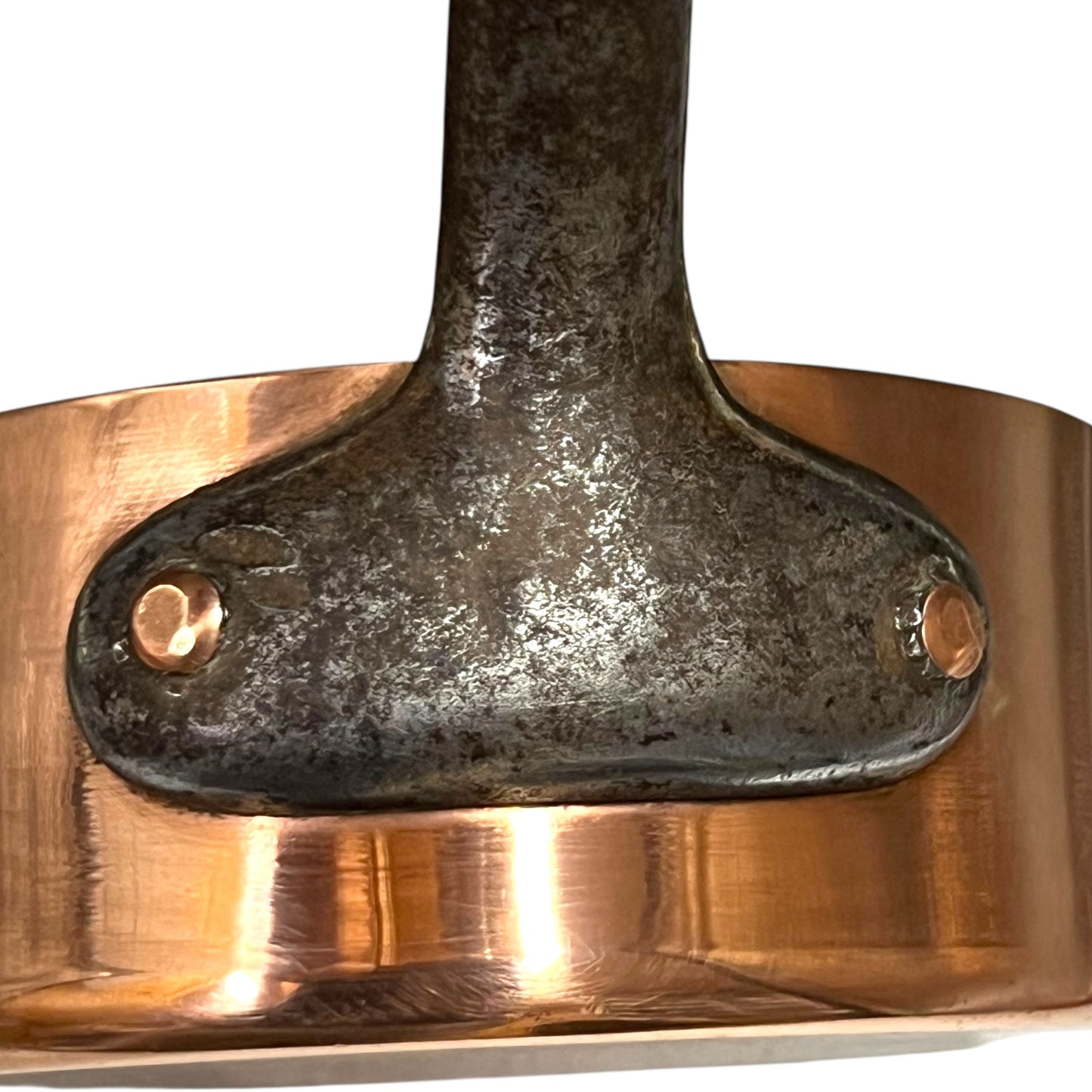 cast iron handle and copper rivets on a French copper pan