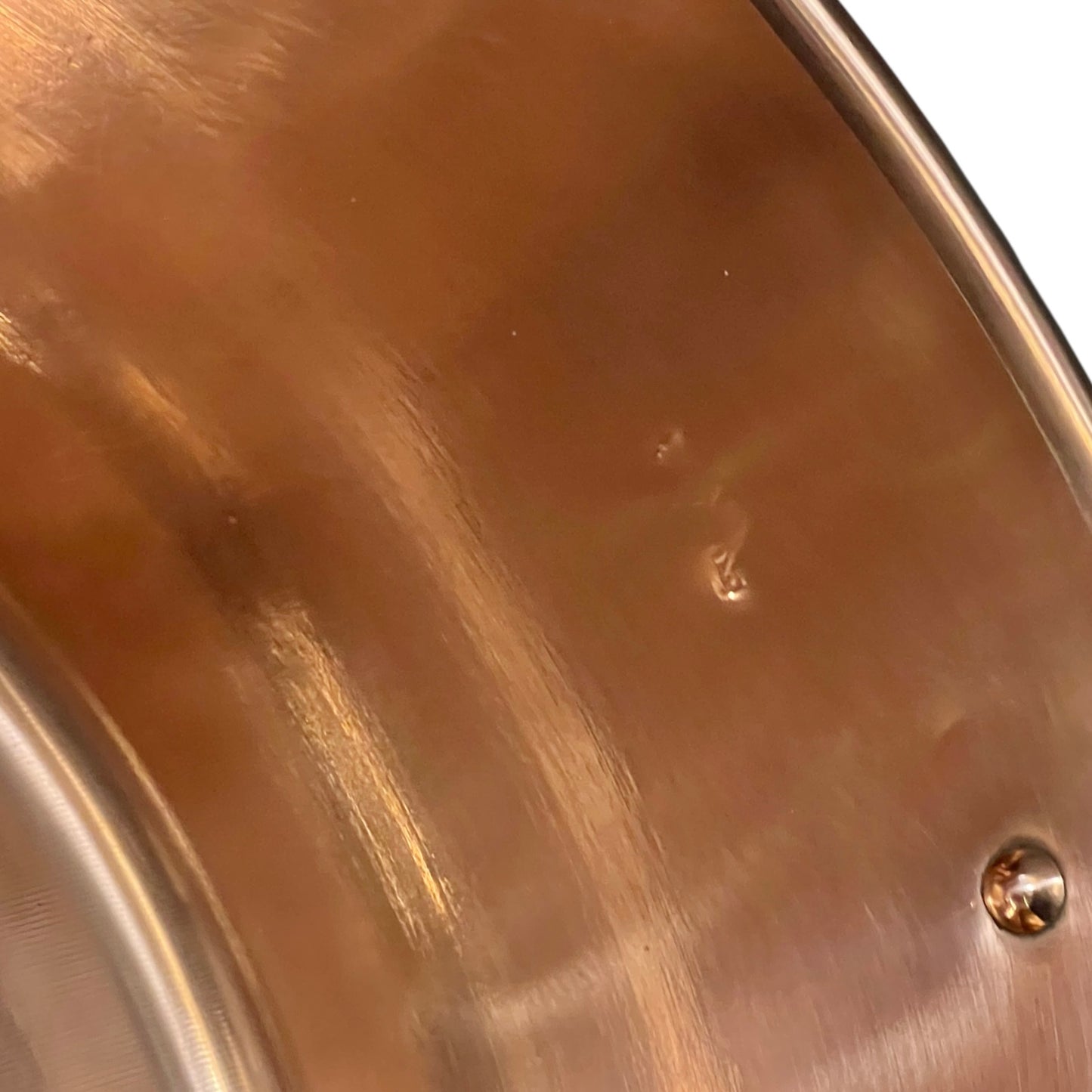 Close up of French copper bowl upcycled into a copper sink with iron handles and a chrome pop up waste on a white background