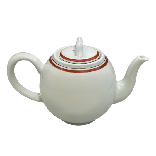 White teapot with a red stripe on the lid against a white background