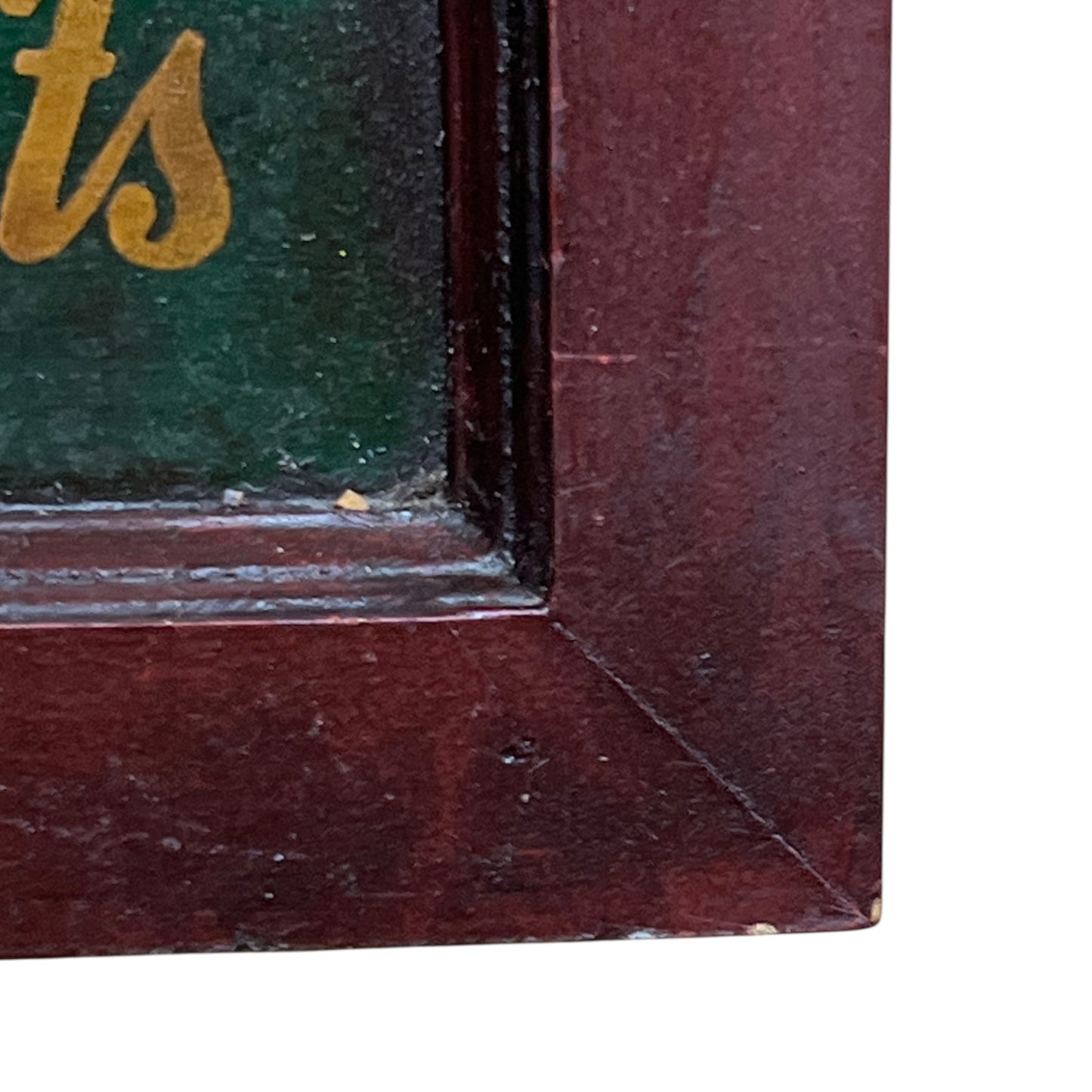 Close-up of a wooden frame corner with a green background