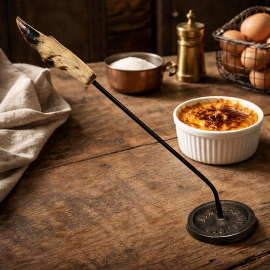 Decorative deer hoof handle salamander with a cast iron handle and base disc on a table with a rustic kitchen background, ideal for a taxidermy collector