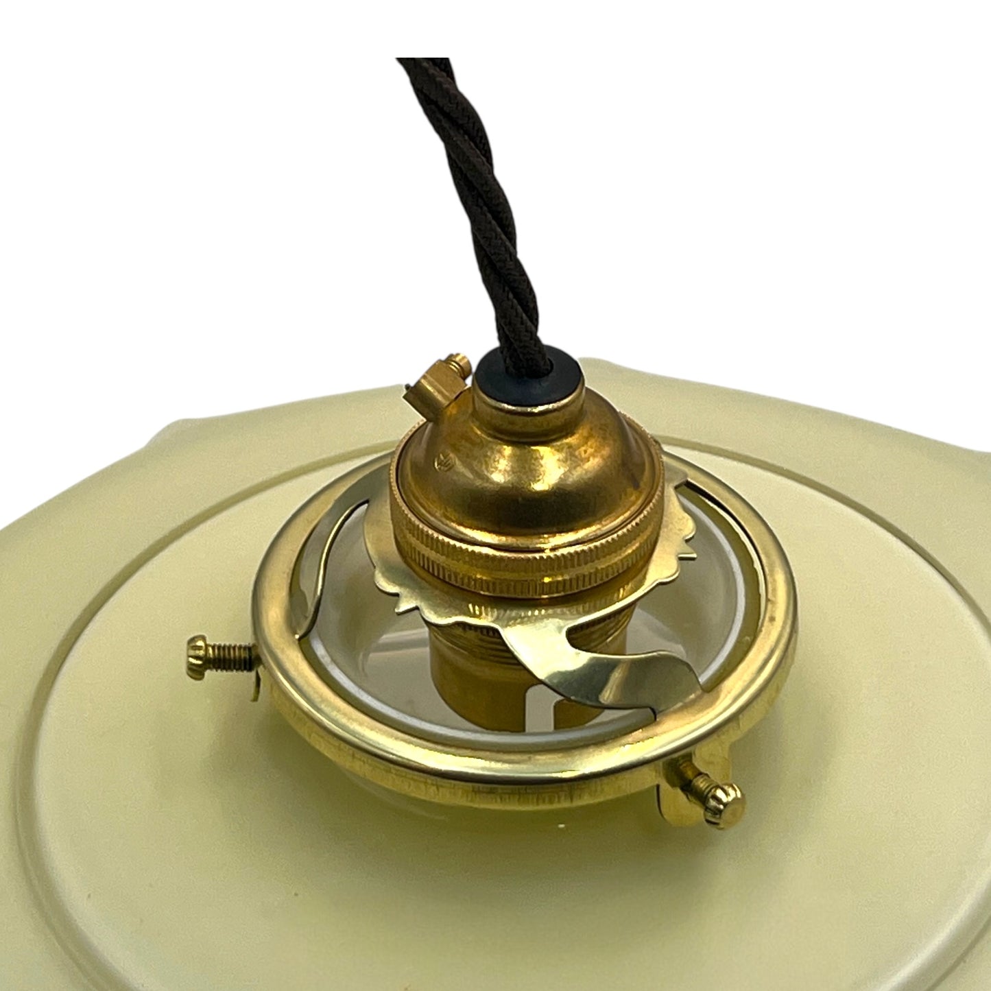 Close-up of a brass lamp fixture with a milk glass shade on a white background