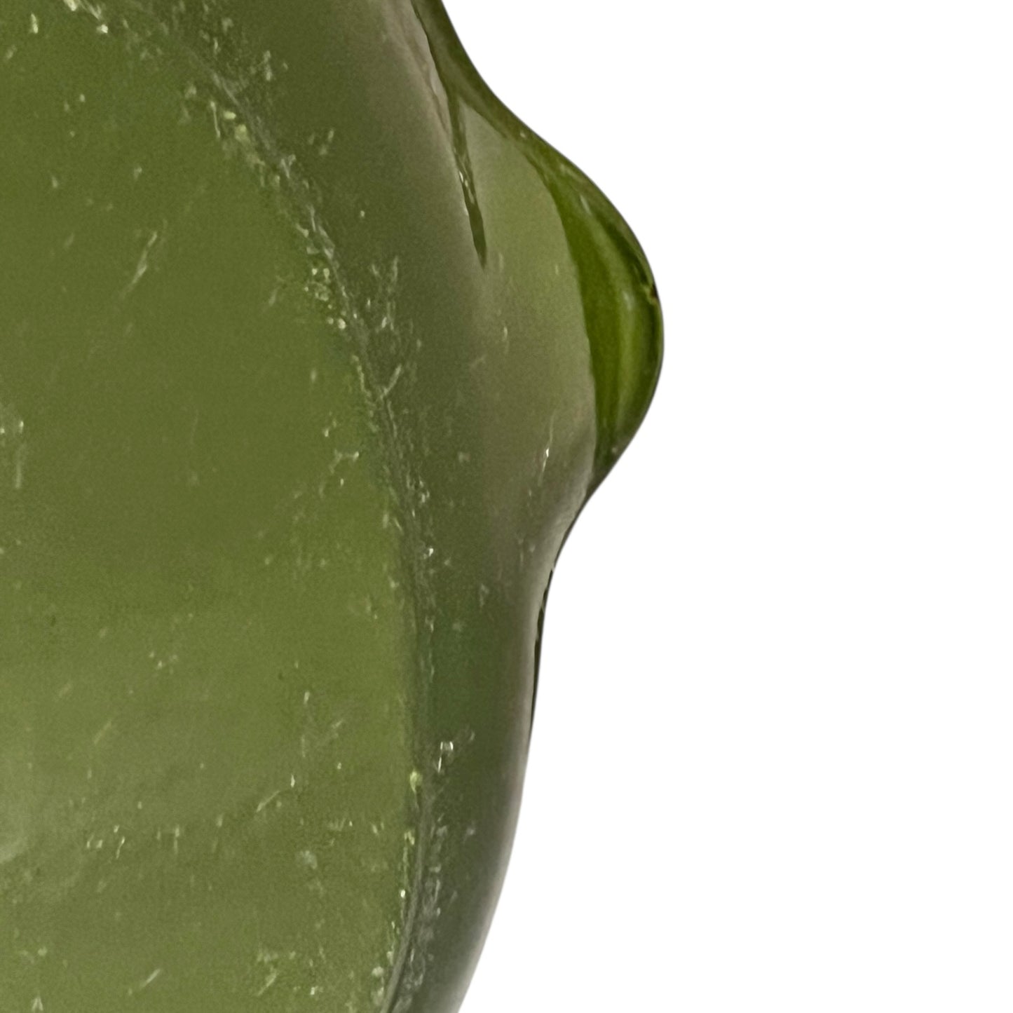 Close-up of a green Le Creuset cast iron skillet on a white background