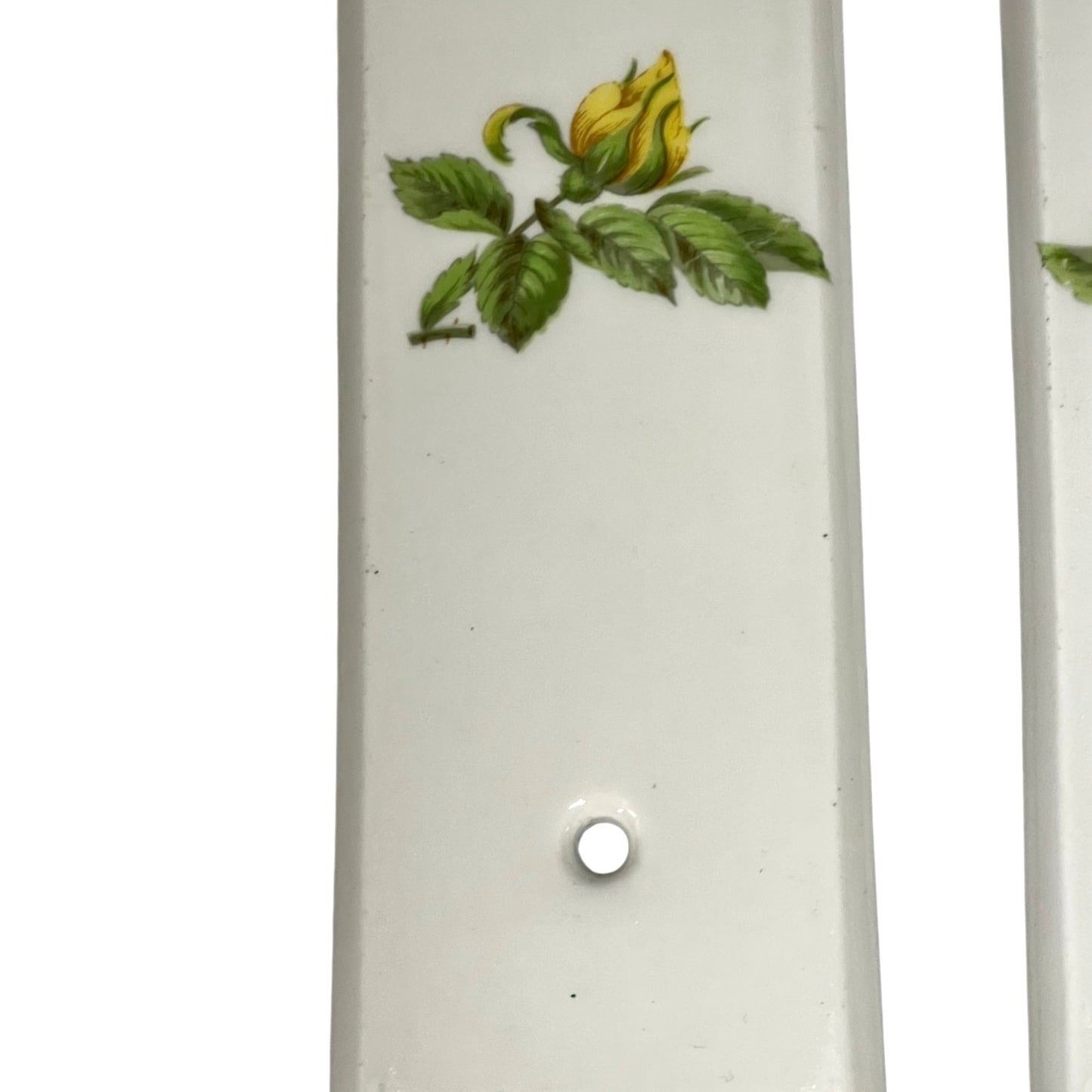 close up of door push plate with a yellow rose decoration on a white background