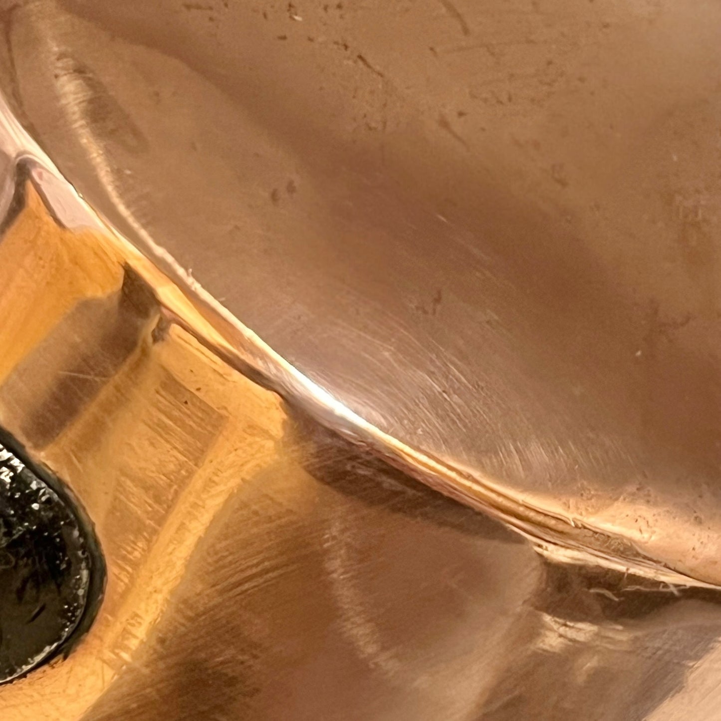 Close-up of a copper pan with a black handle on a white background
