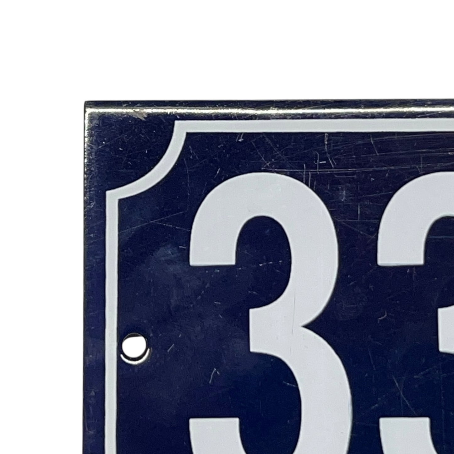 Close-up of a blue sign with white numbers '33' on a white background