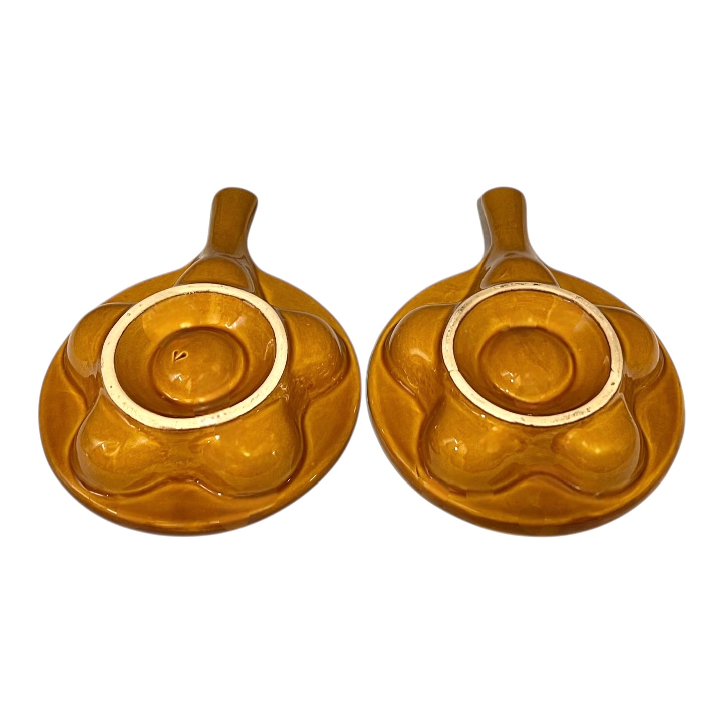 pair of amber-coloured French ceramic escargots plates with handles on a white background