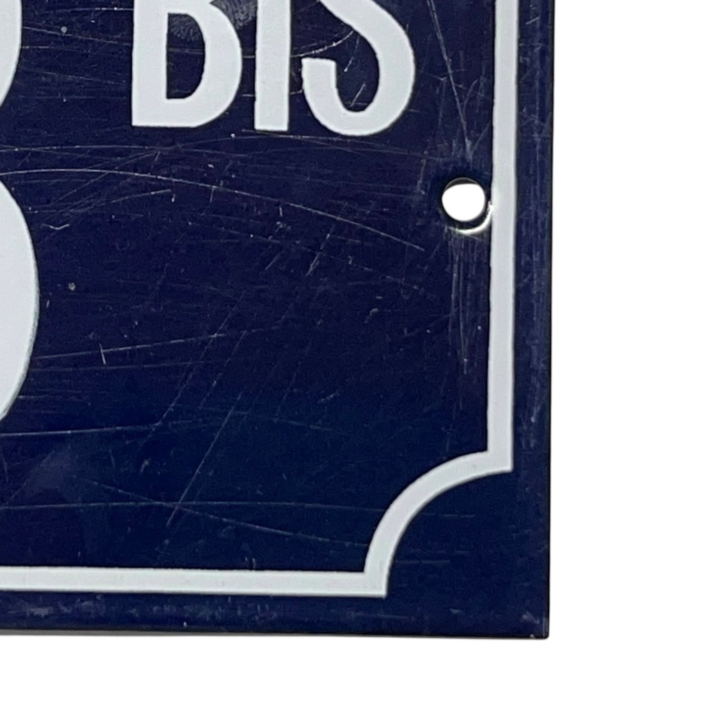 Close-up of a blue sign with white text and border, showing signs of wear.