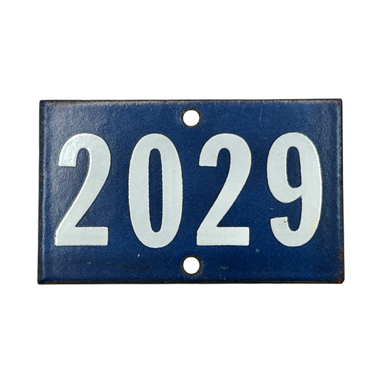 Blue and white vintage enamel door number 2029 on a white background