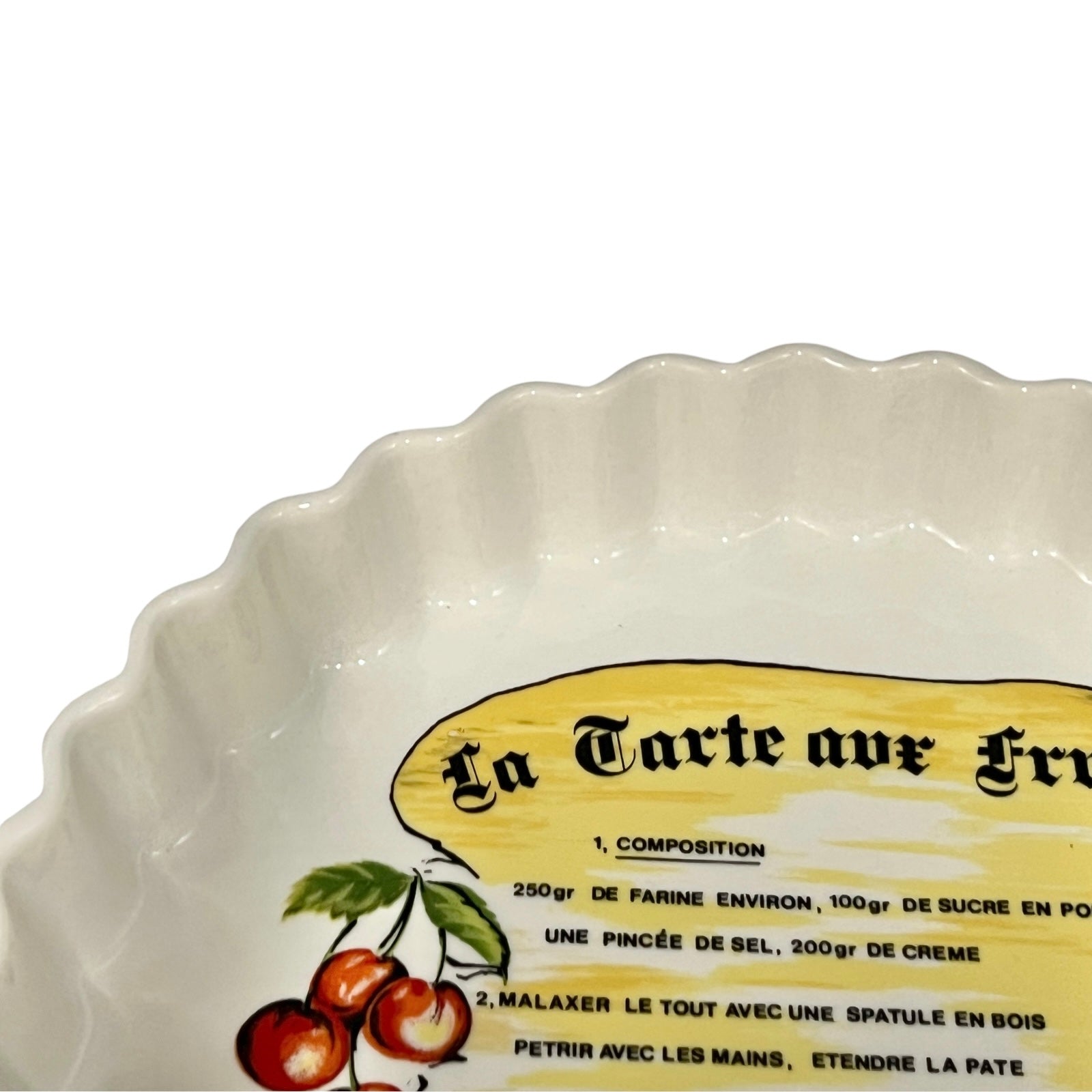 White ceramic tart dish with a decorative label featuring cherries on a white background