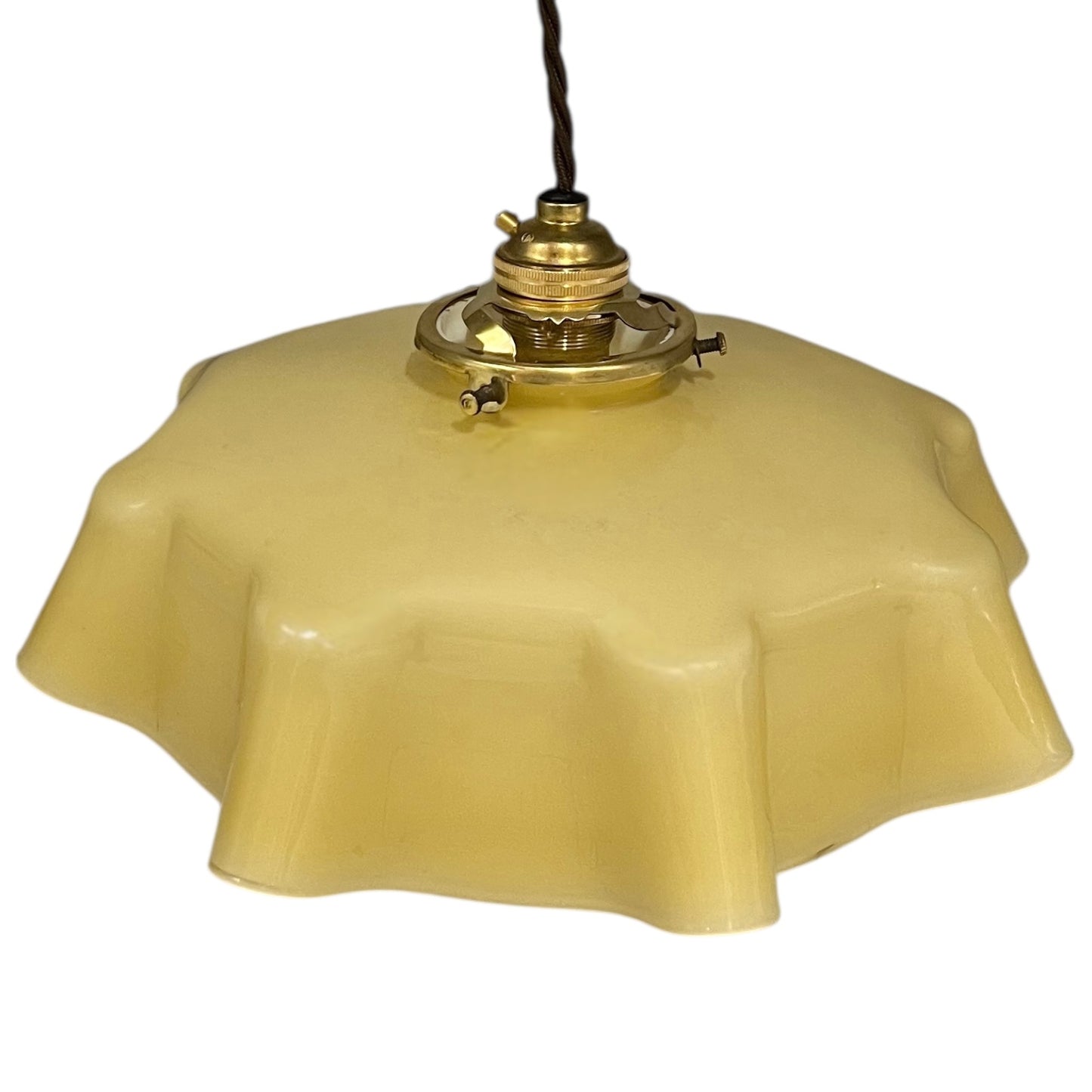 Vintage-style pendant light with a yellow glass shade and brass fitting on a white background