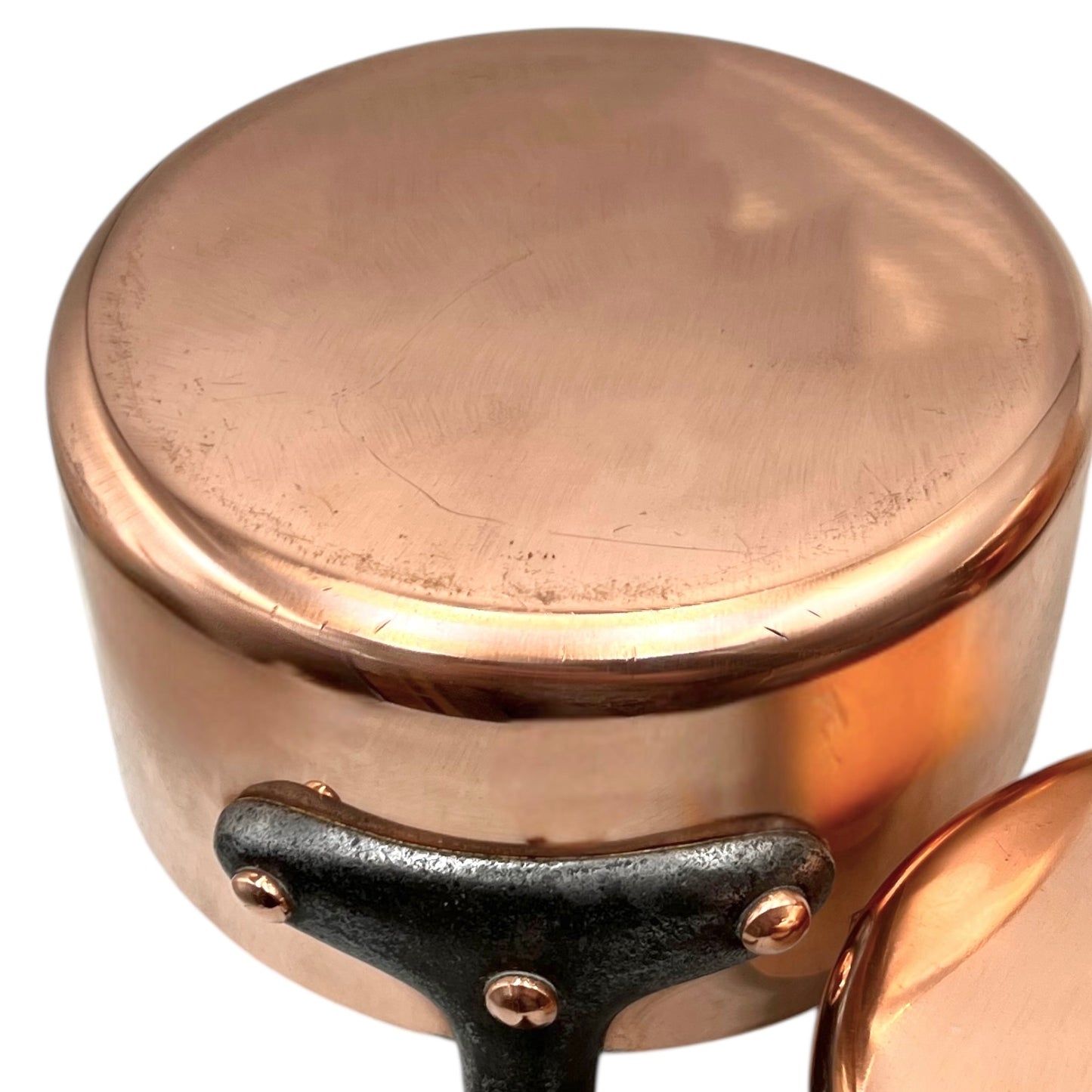 Close-up of a copper pot with a black handle on a white background