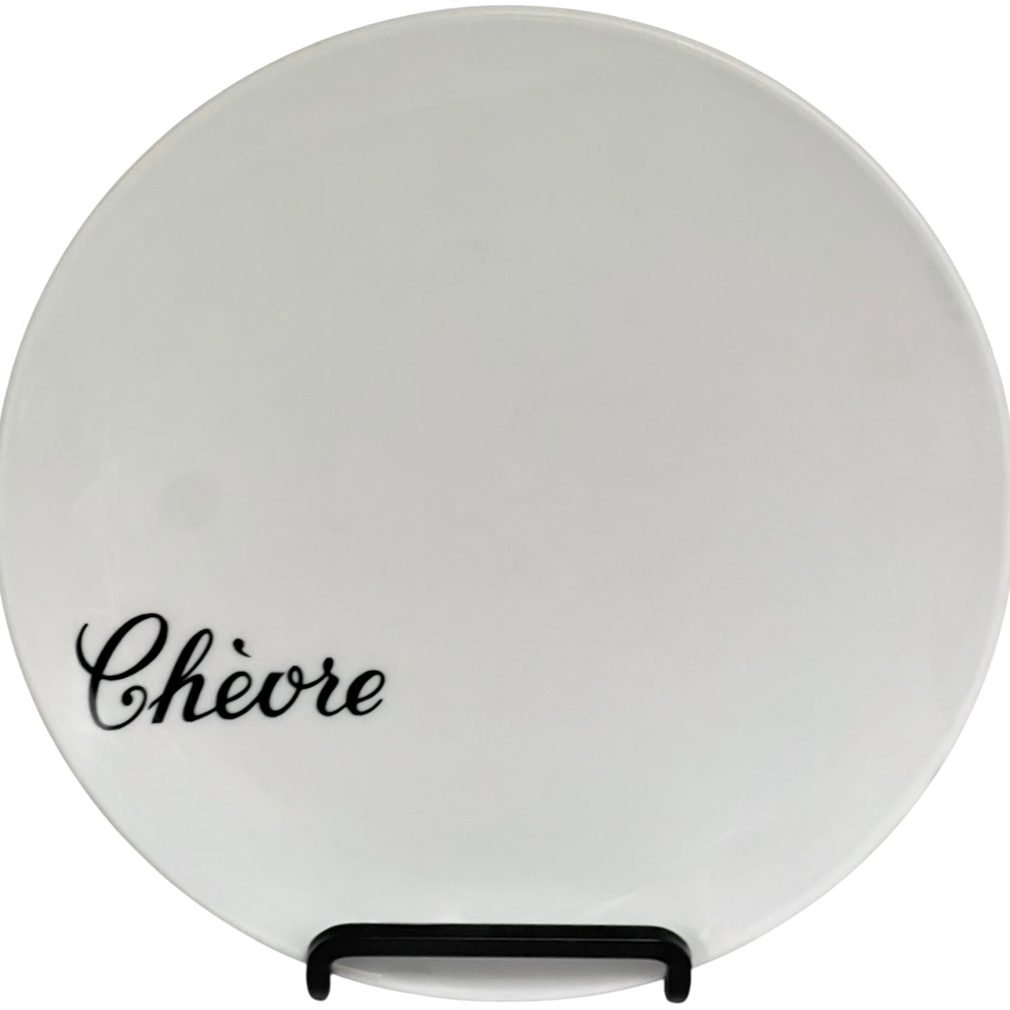 Round white plate with 'Chevere' text on a stand against a white background