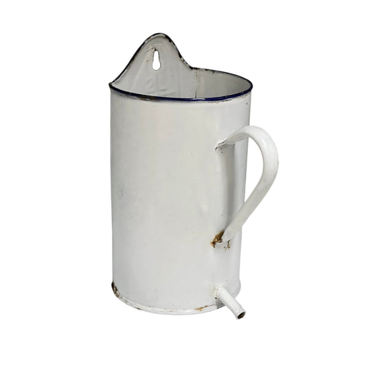 A vintage white enamel pitcher planter jug with a blue rim, featuring a handle, pouring spout, and top carrying loop, shown against a plain white background.